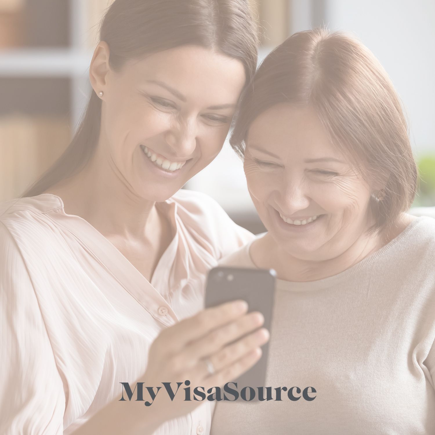 mother and daughter laughing while watching cell my visa source