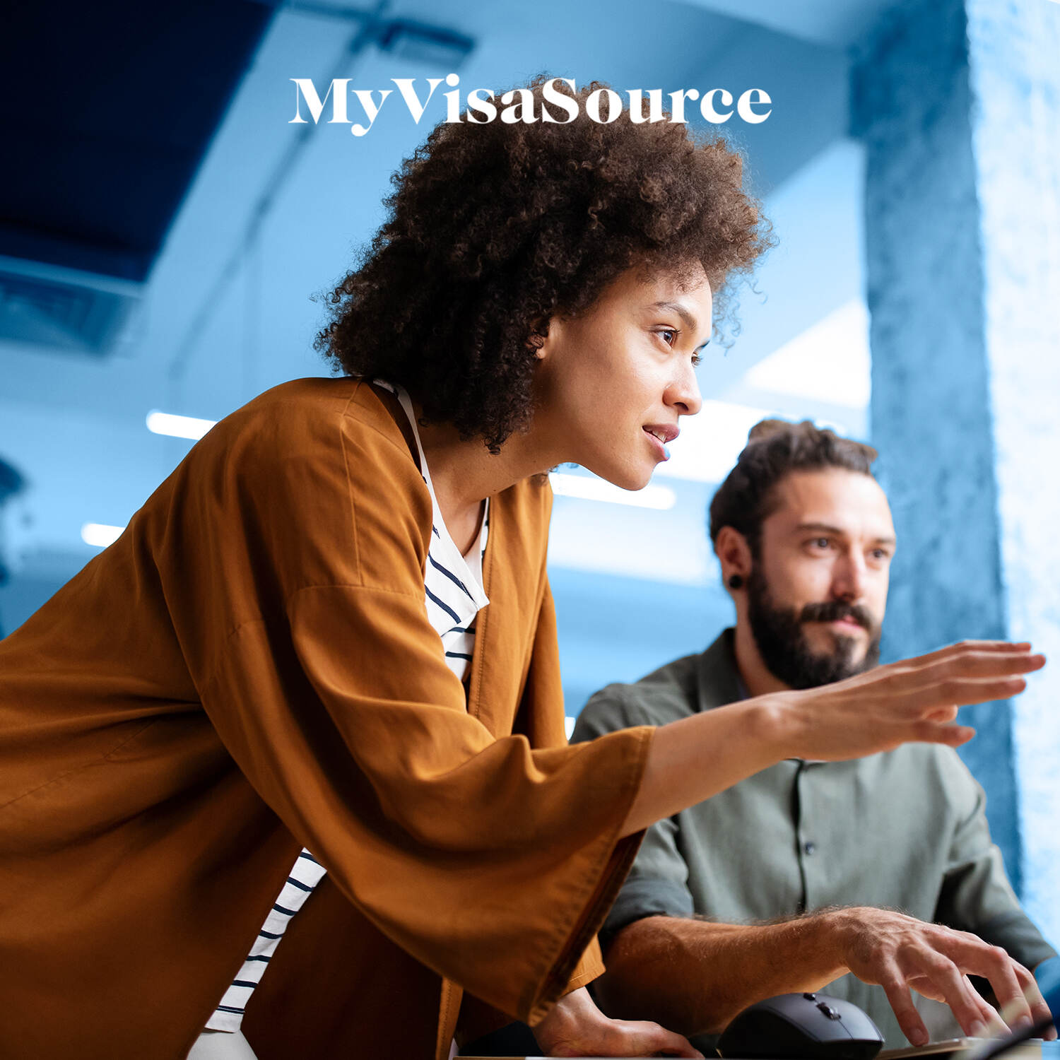 two cheerful co workers working infront of computer my visa source