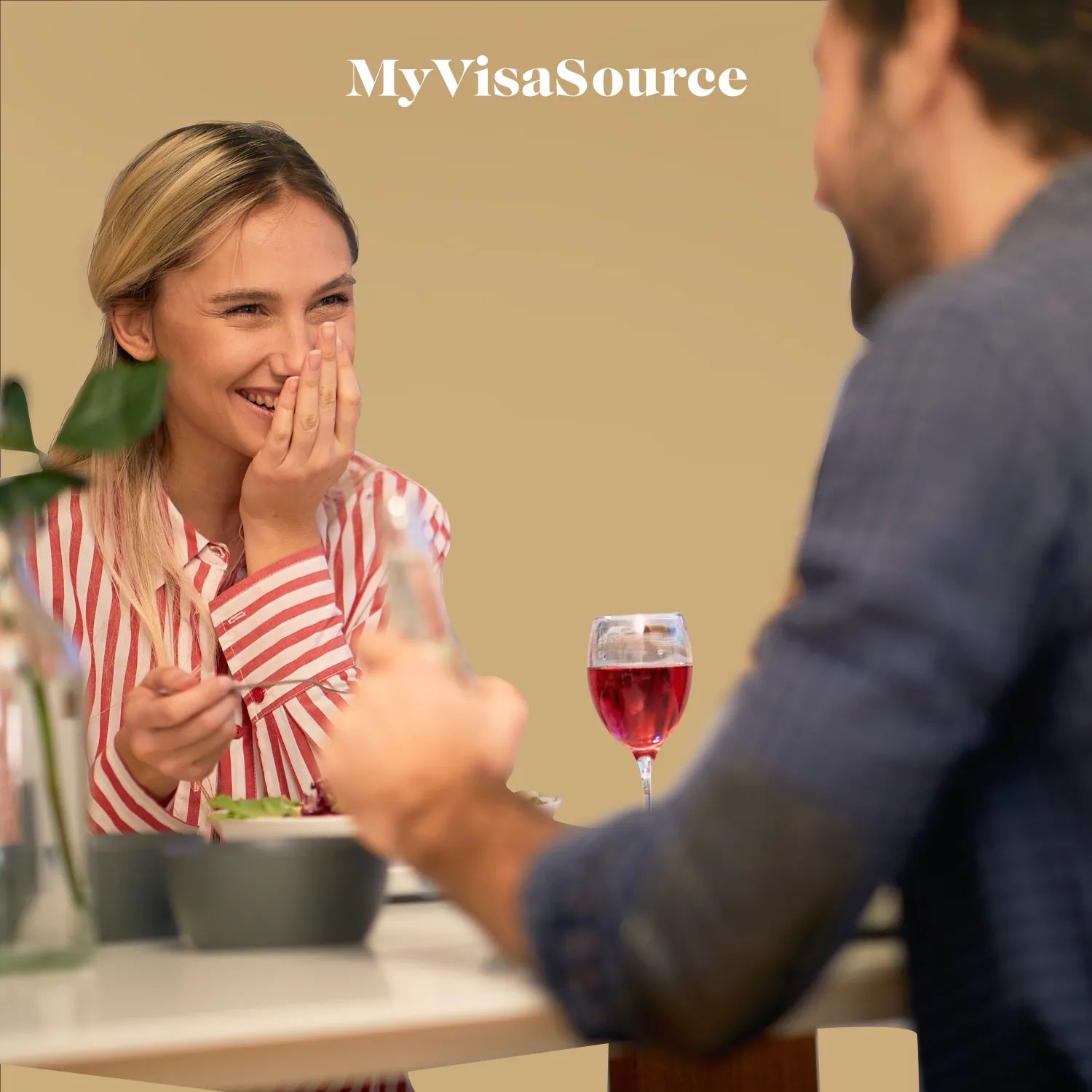 cheerful couple sharing a meal with brown background by my visa source