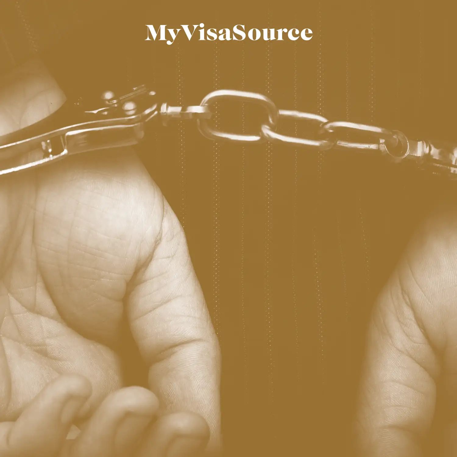 close up of hands that are handcuffed with brown filter over the image by my visa source