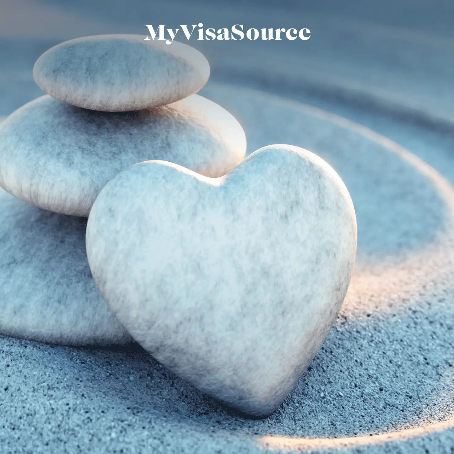 smooth stones stacked together with one shaped like a hear all on sand