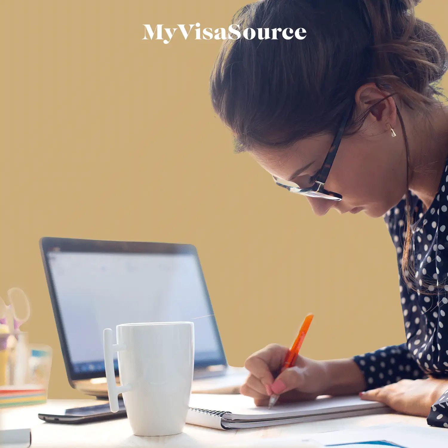 young woman focused taking notes with laptop in front of her with brown background