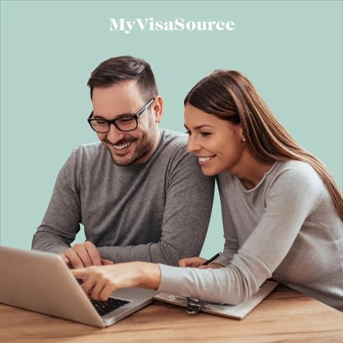 a young woman holding a laptop by my visa source
